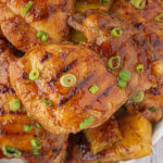 Close-up of the finished chicken garnished with grill marks and green onions.