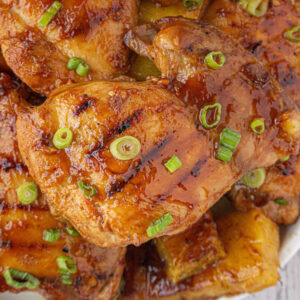 Close-up of the finished chicken garnished with grill marks and green onions.