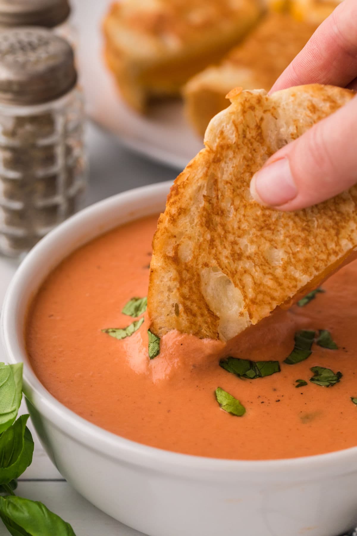 A bowl of tomato soup and a grilled cheese sandwich.