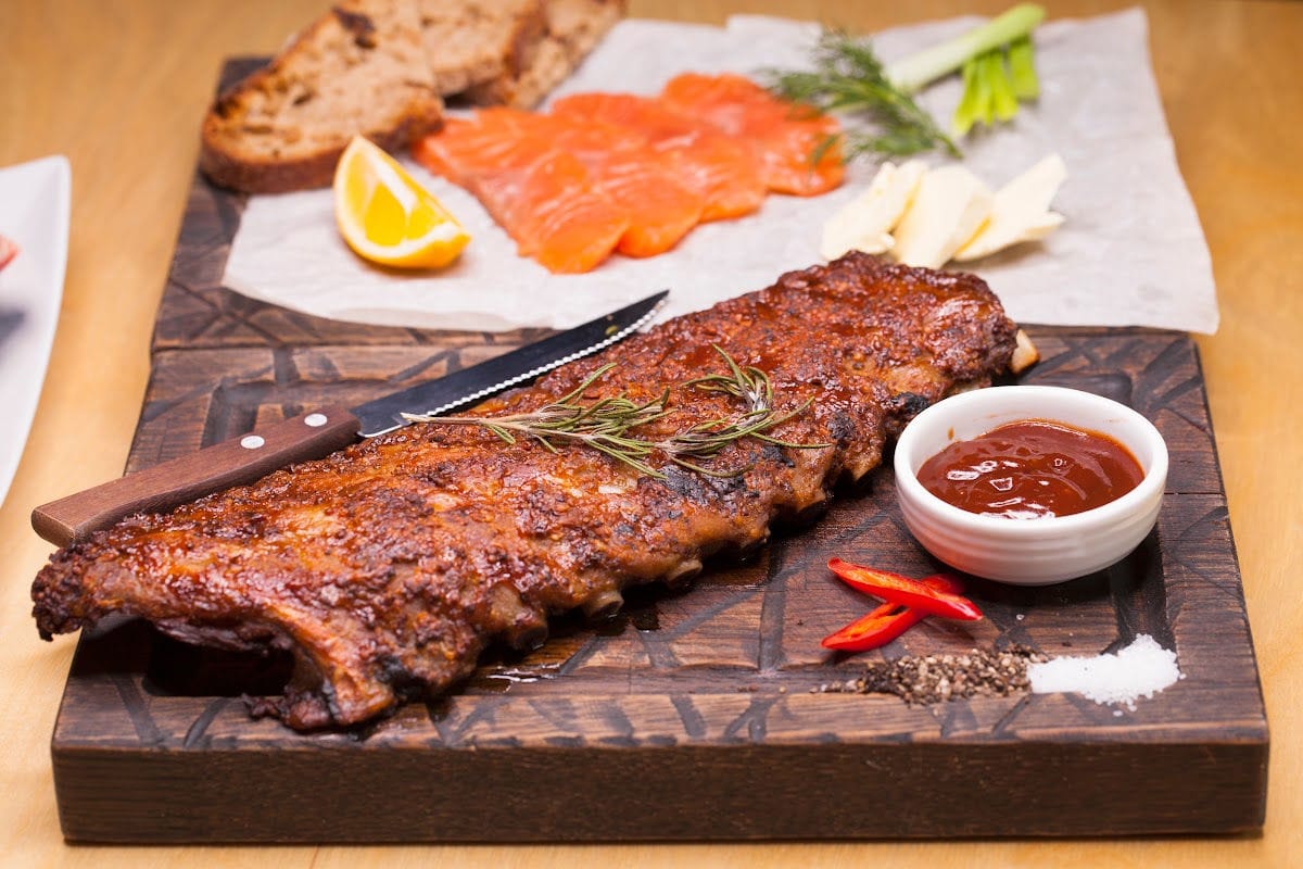 A rack of bbq ribs on a table ready to be eaten.