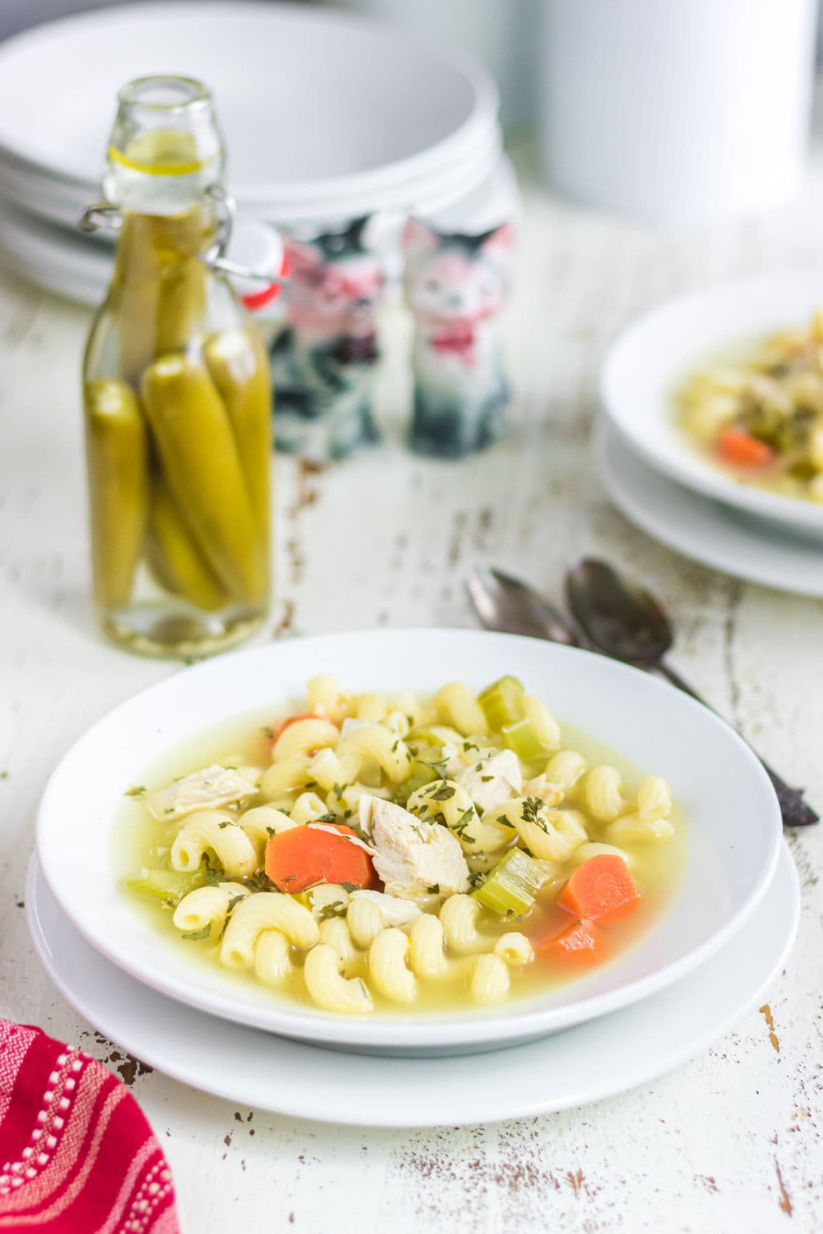 A table with two bowls of chicken soup on it.