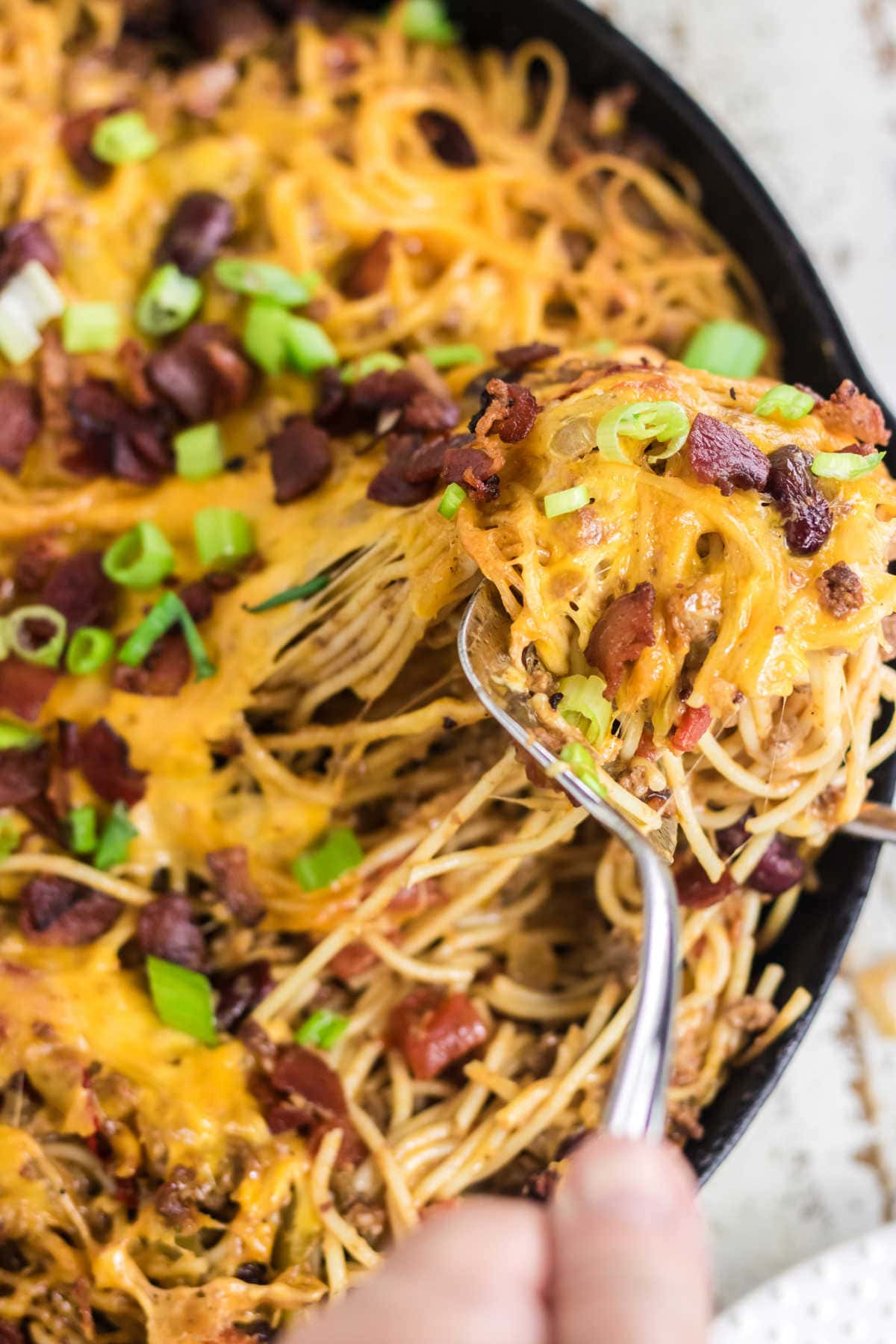 Closeup of the spaghetti casserole with a serving being removed.