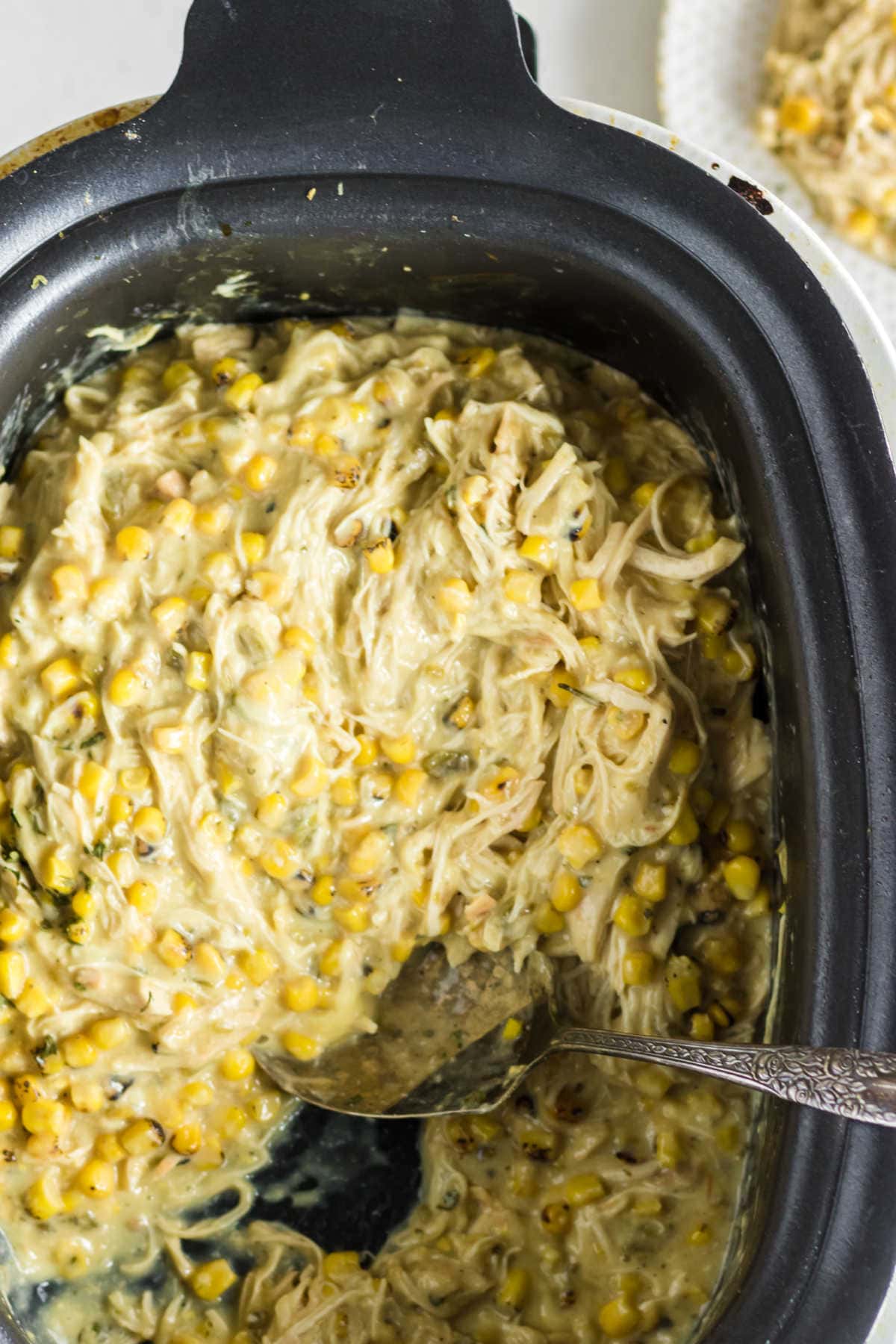 Overhead view of a slow cooker filled with creamy shredded chicken.