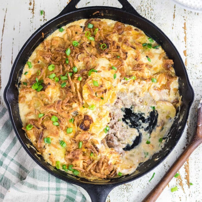 Overhead view of the casserole in a skillet with a serving removed.