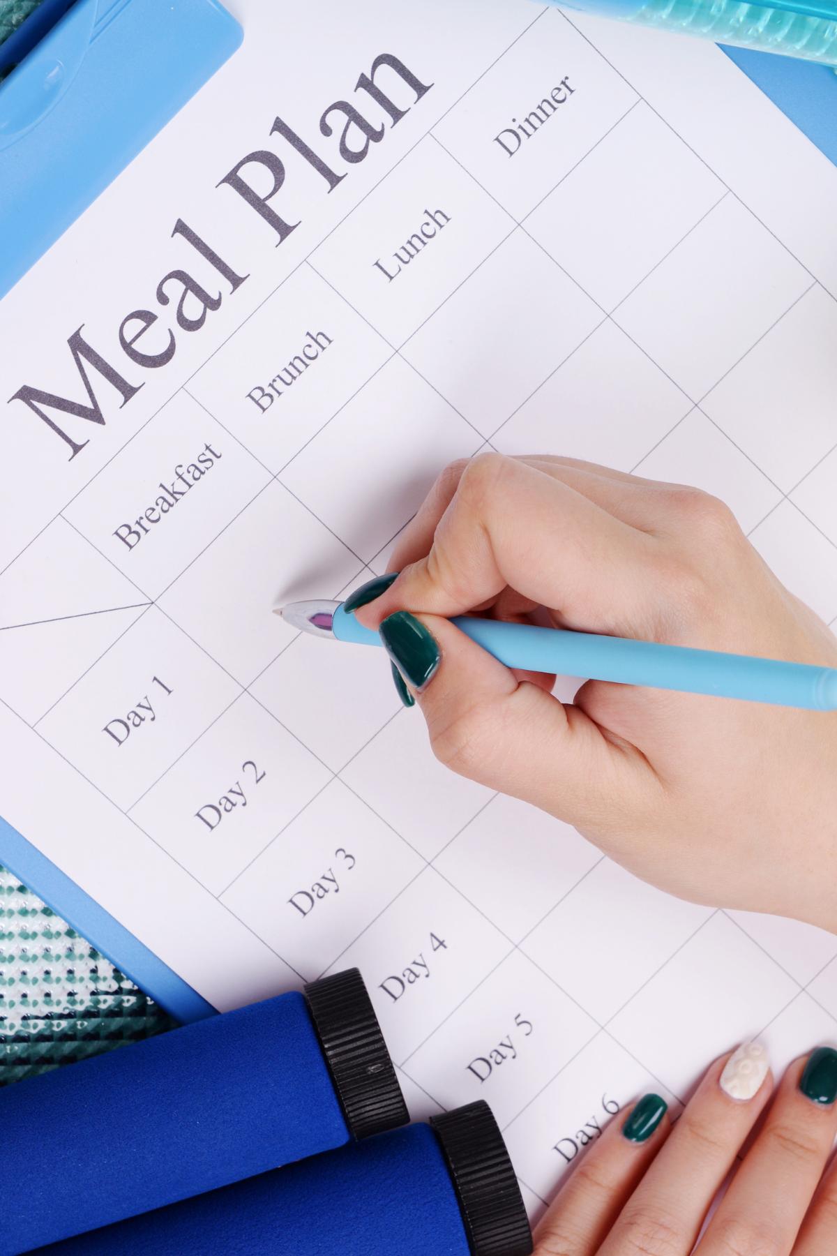 Someone filling in a meal plan sheet.