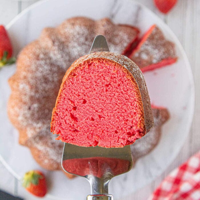 A slice of pink strawberry pound cake on a cake server.