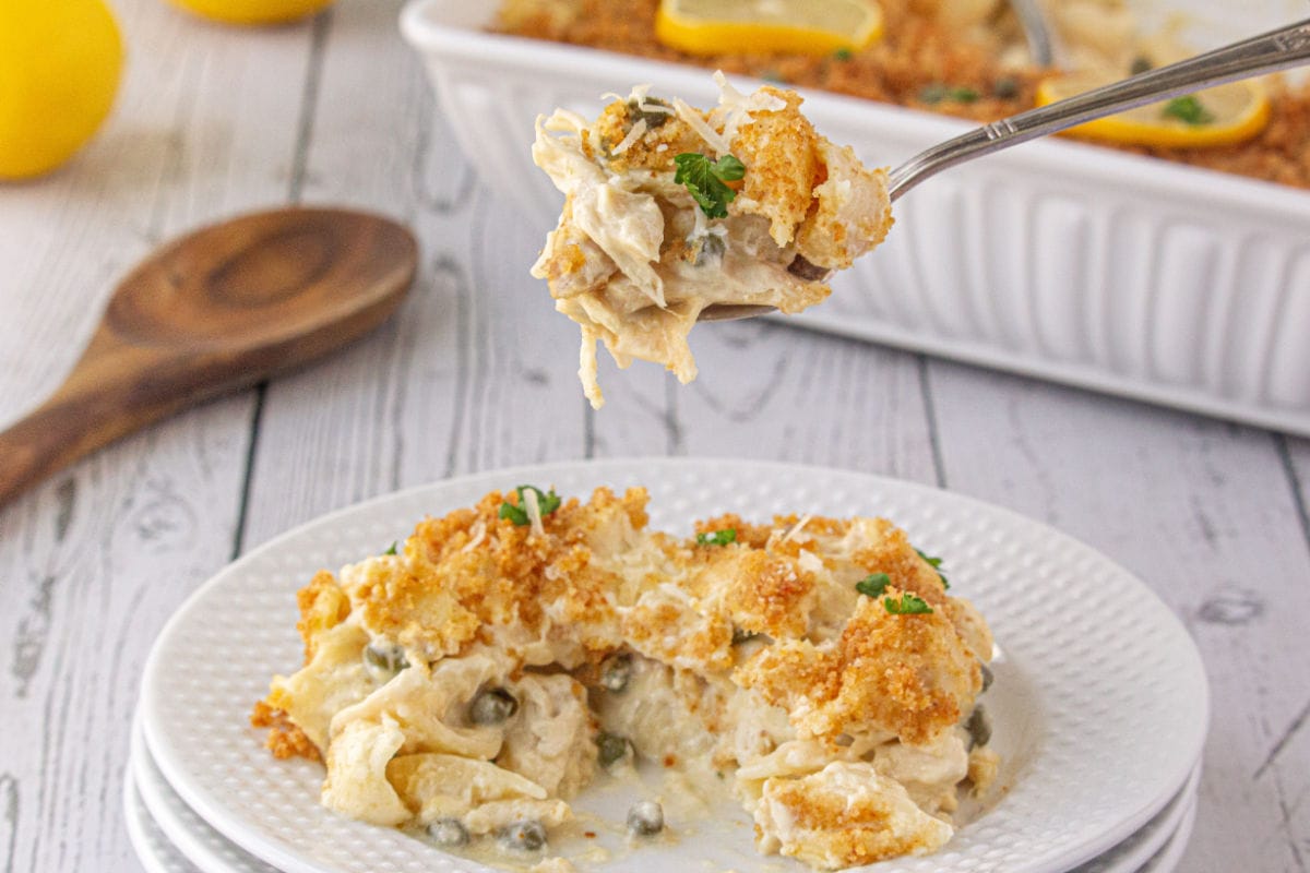 A serving of chicken piccata casserole on a plate with some on a fork.