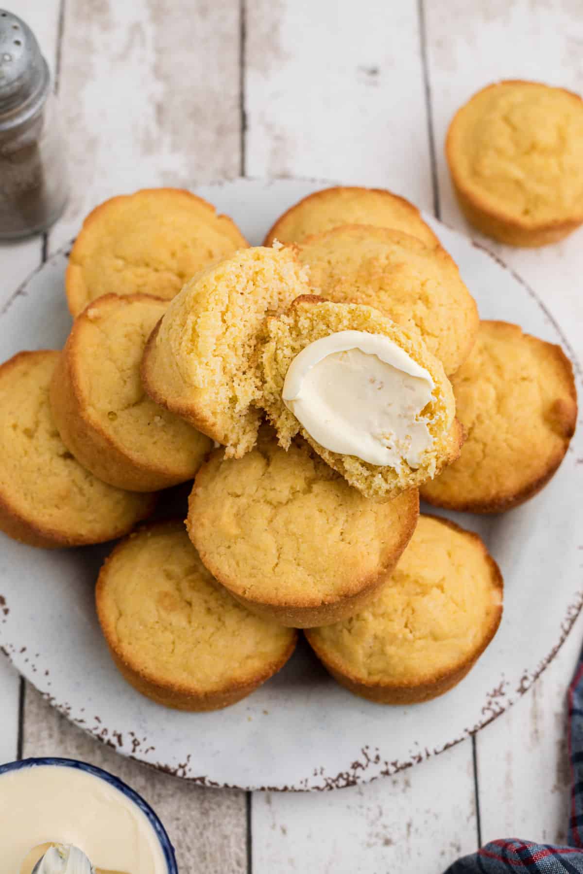 A pile of cornbread. muffins on a plate.