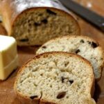 A slice of kalamata olive bread with text overlay for Pinterest.