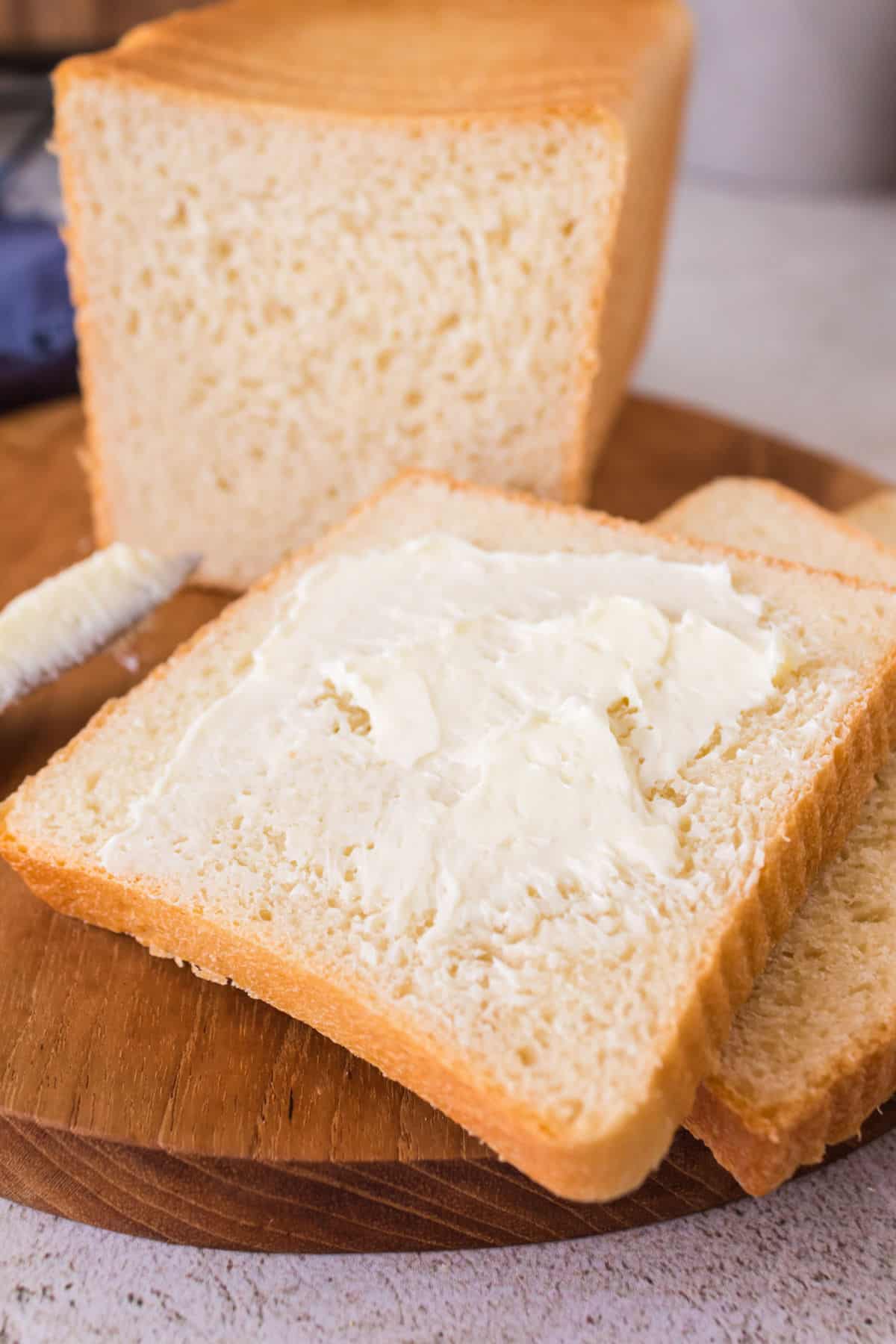 Sliced homemade Pullman bread spread with butter.