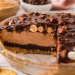 A side view of the pie with a slice removed to show layers of chocolate and peanut butter.