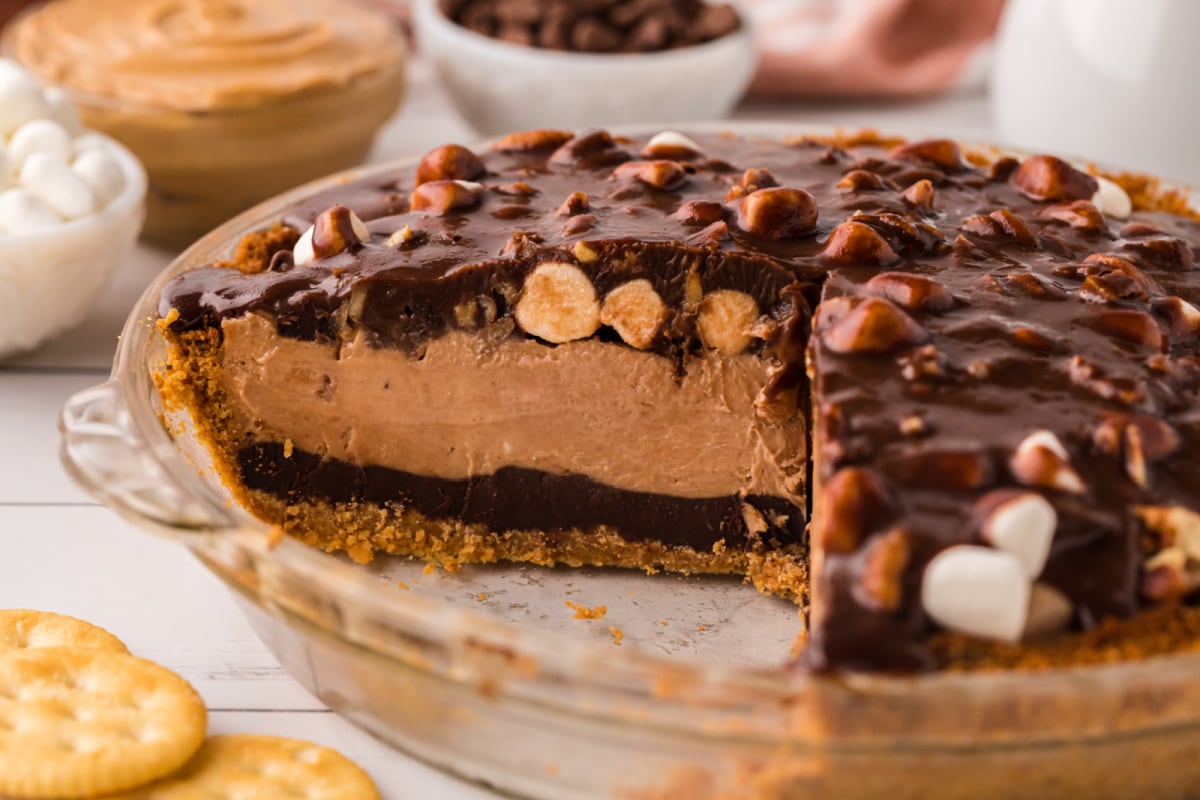 A side view of the pie with a slice removed to show layers of chocolate and peanut butter.