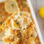 Overhead view of chicken piccata casserole being served. There is a title text overlay for Pinterest.