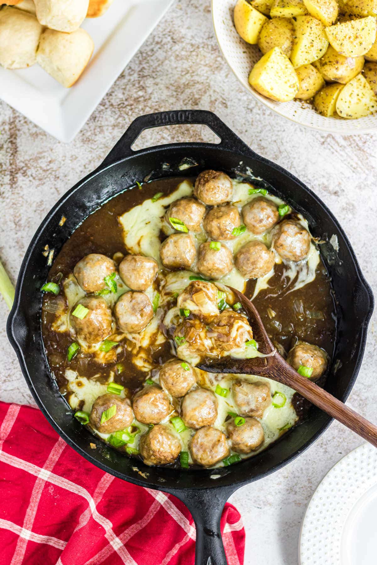 Overhead view of an iron skillet filled with meatballs that are ready to eat.