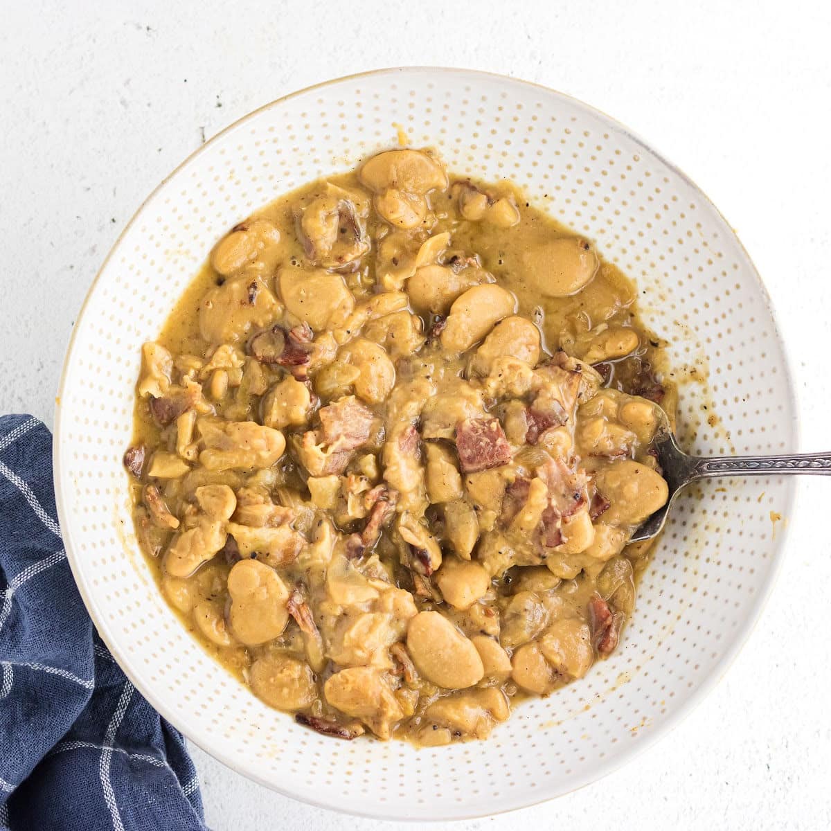 Overhead view of a bowl of butterbeans with bacon.