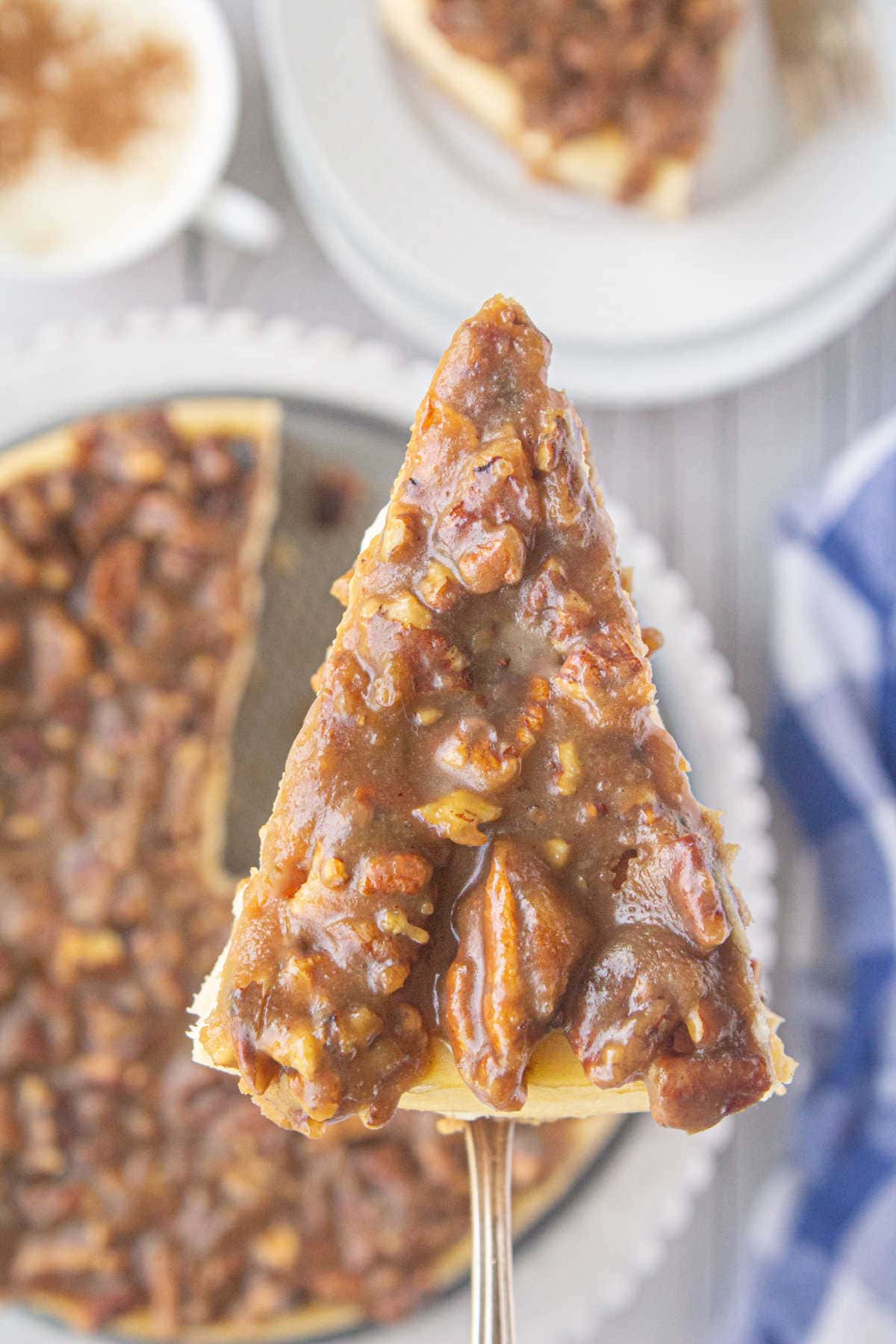 A slice of pecan pie cheesecake being served.