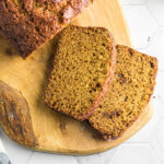 Slices of golden brown acorn squash bread on a cutting board.