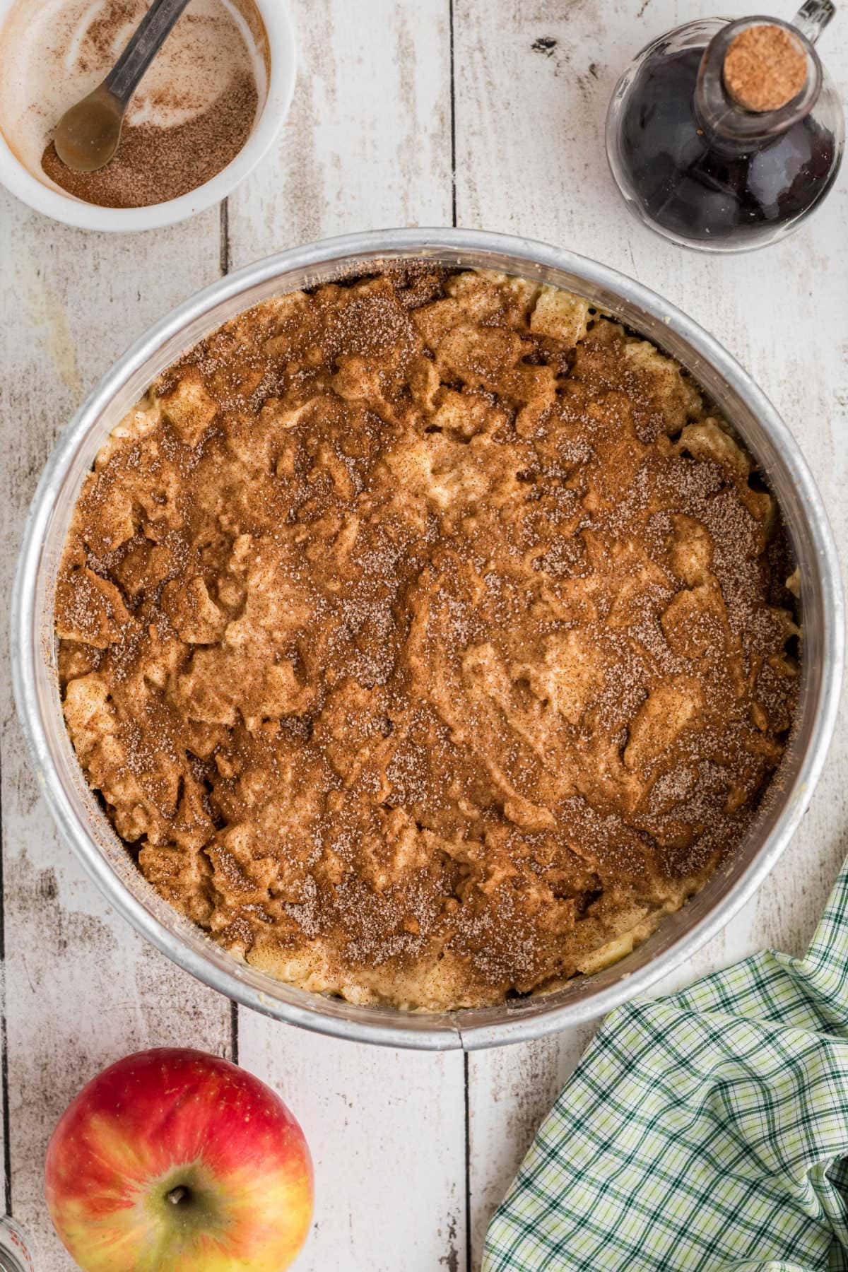 Adding cinnamon mixture to the top of the cake batter.