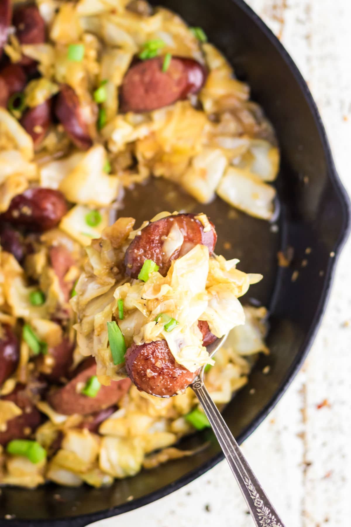 Closeup of a pan of kielbasa and cabbage.