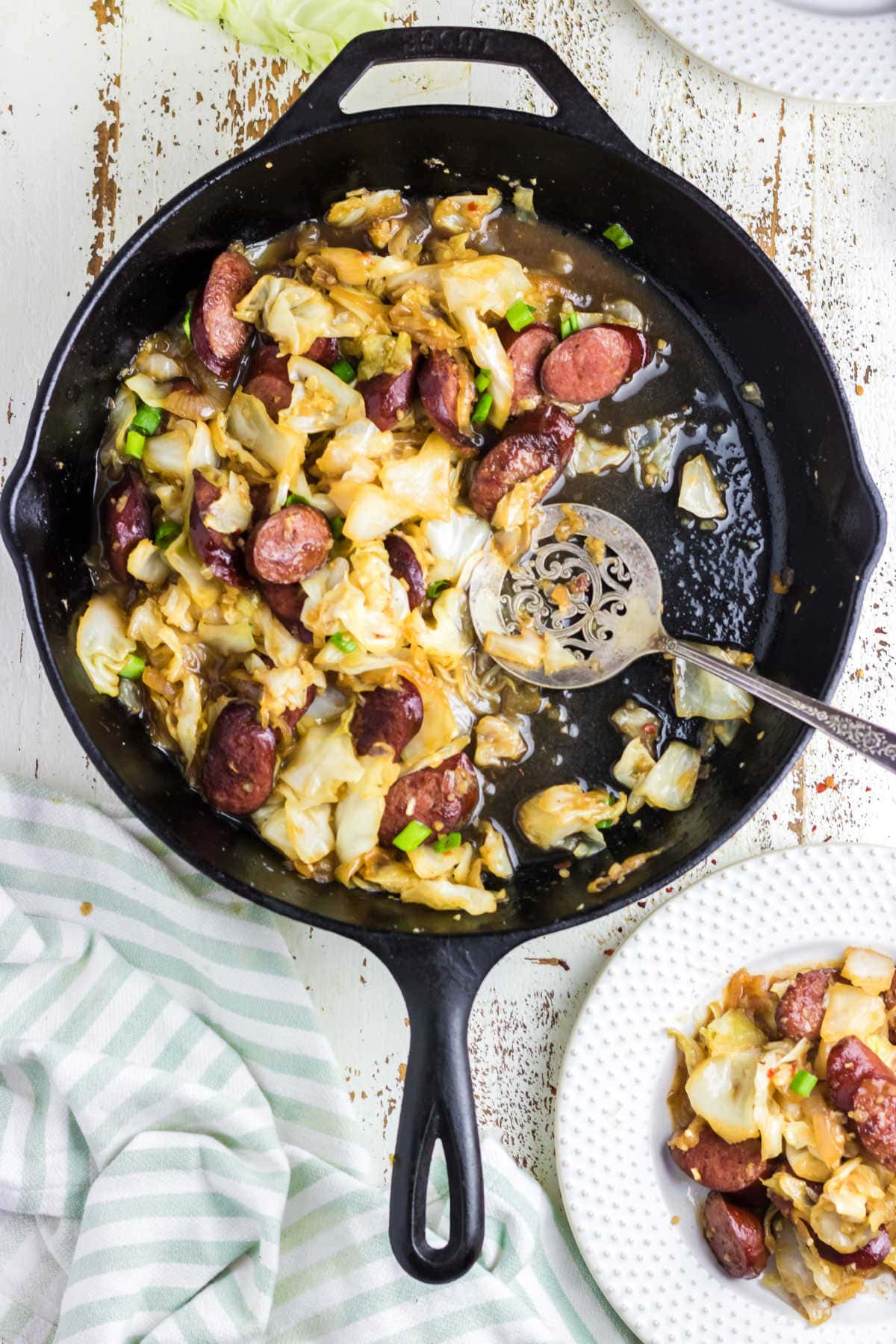 Overhead view of an iron skillet with kielbasa and cabbage.