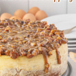 Uncut pecan pie cheesecake on a cake plate with text overaly for Pinterest.