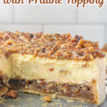 A cheesecake with a slice removed showing the layers of pecan pie and cheesecake. Text overlay for pinterest.