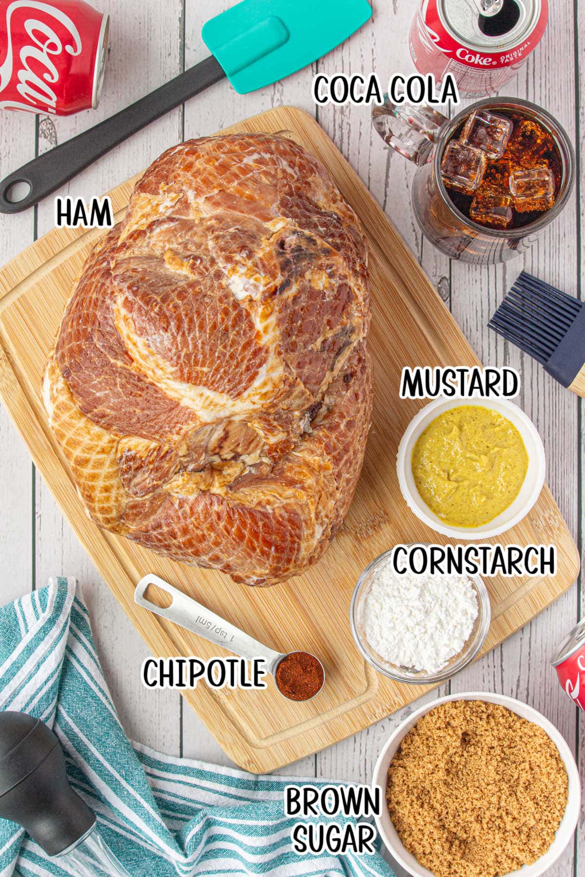 An overhead photo of the ingredients. The ham is on a cutting board, while the coca cola glaze ingredients are in small bowls.