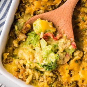 Cheesy broccoli and stuffing casserole being scooped out of the casserole dish.
