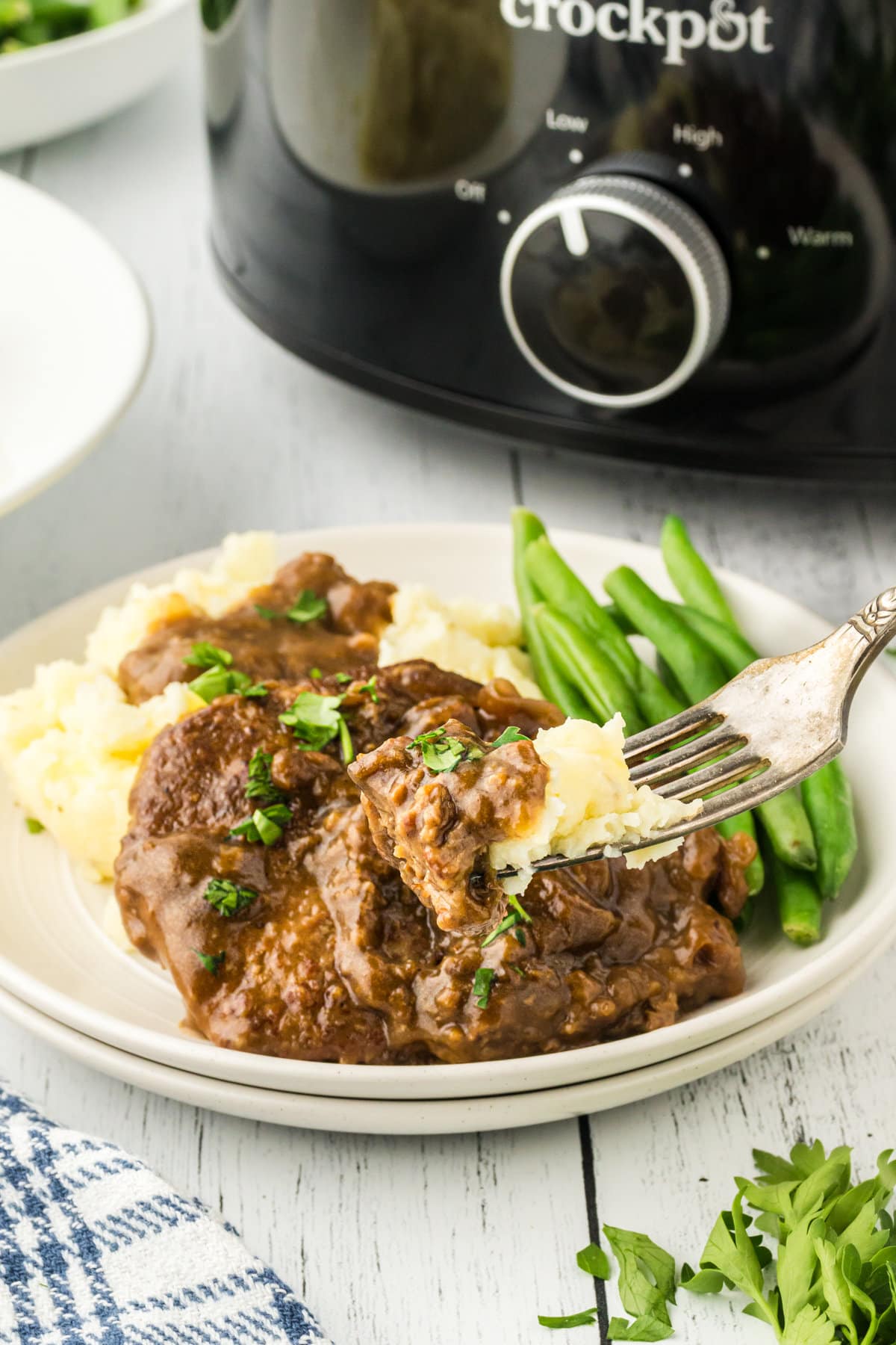 A plate of steak and gravy with mashed potatoes on a table.