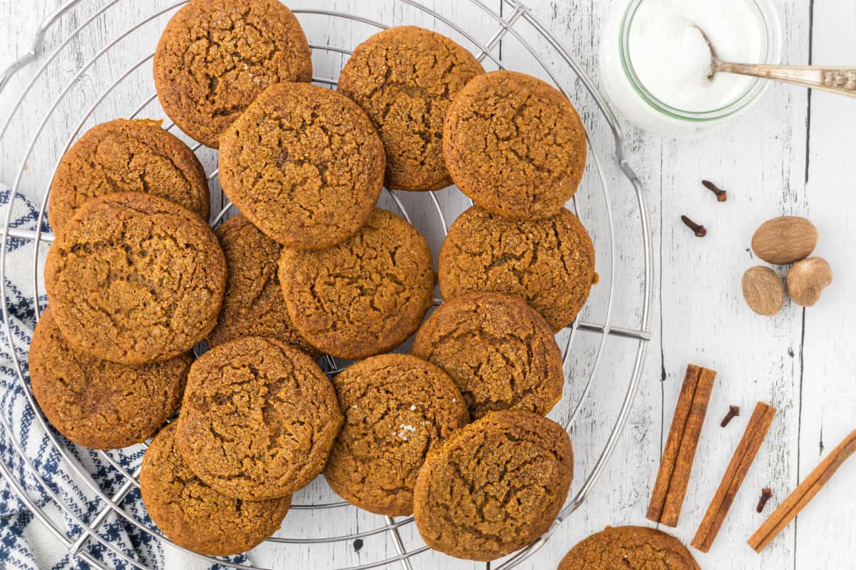 Finished molasses cookies with crinkly tops on a cooling rack.