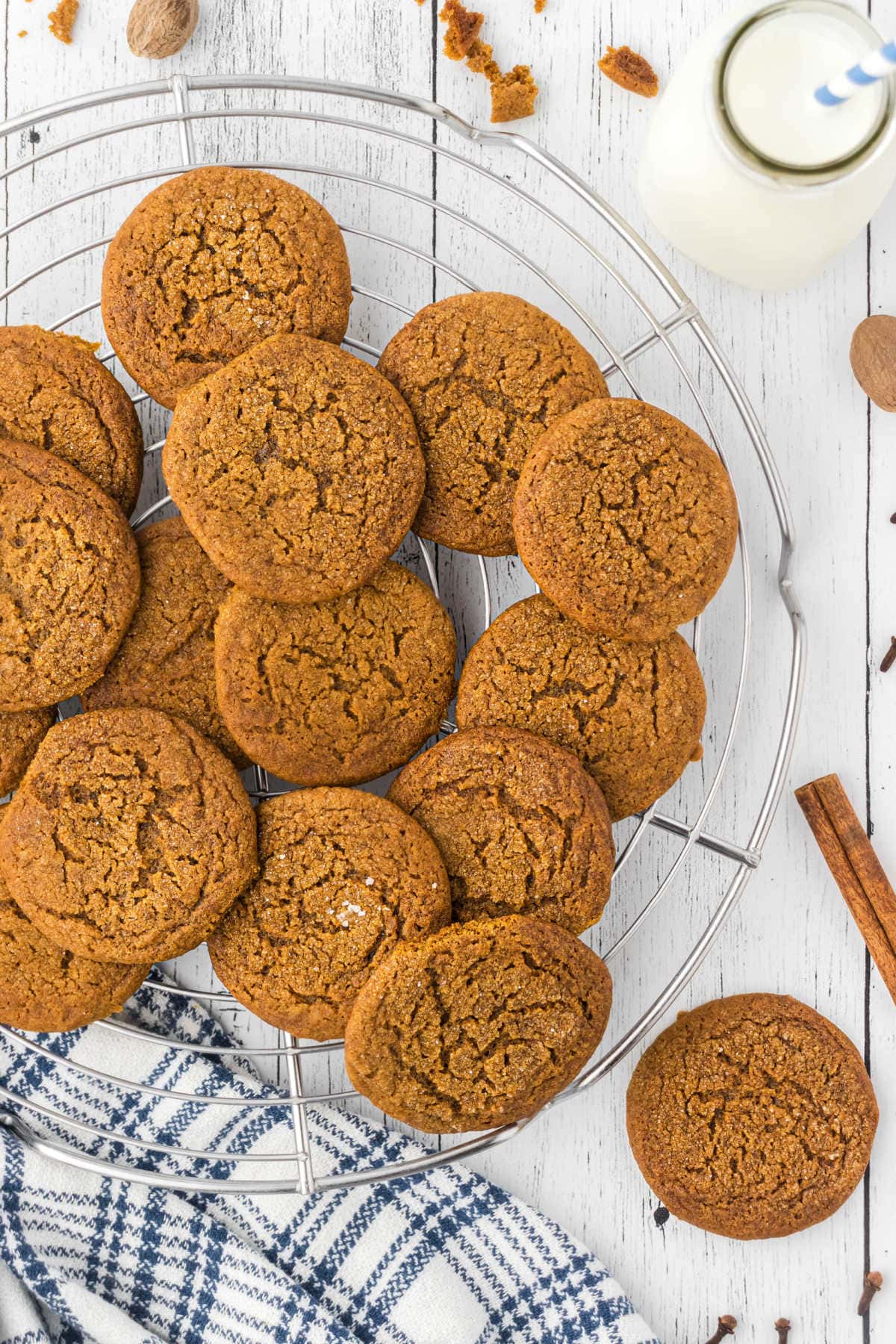 A pile of old fashioned molasses cookies on a cooling rack.