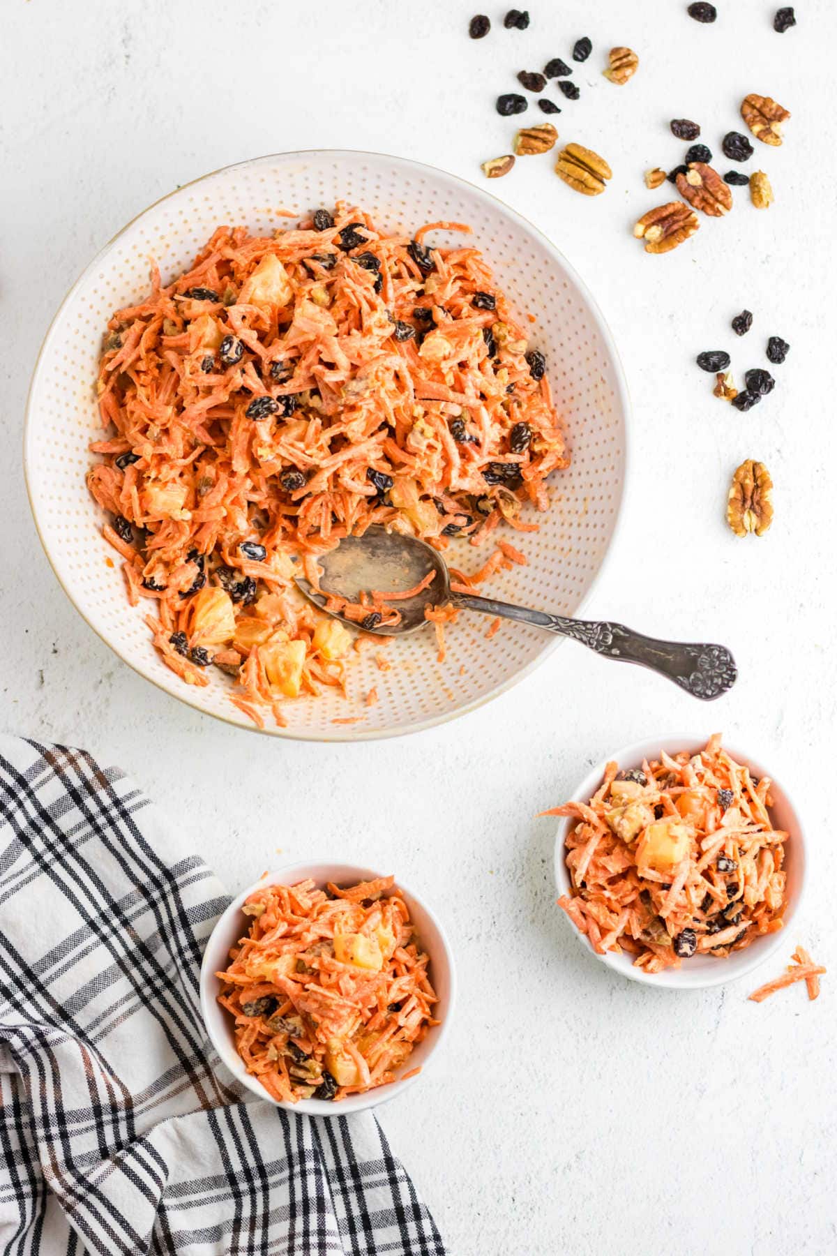 Overhead view of carrot raisin salad in a white bowl.