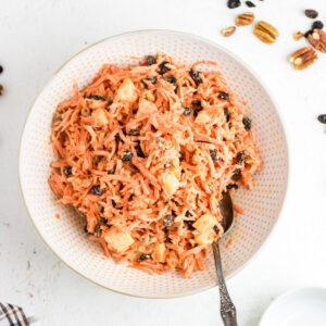 Overhead view of carrot raisin salad with pineapple and pecans mixed in.