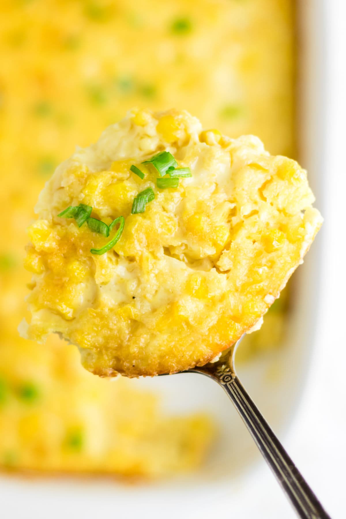 A serving of corn pudding being removed from the dish.