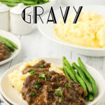 Cube steaks covered with gravy on a plate with mashed potatoes and a title text overlay for Pinterest.