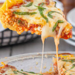 A slice of spaghetti pie being served with gooey cheese dripping off the sides and a text overlay for Pinterest.