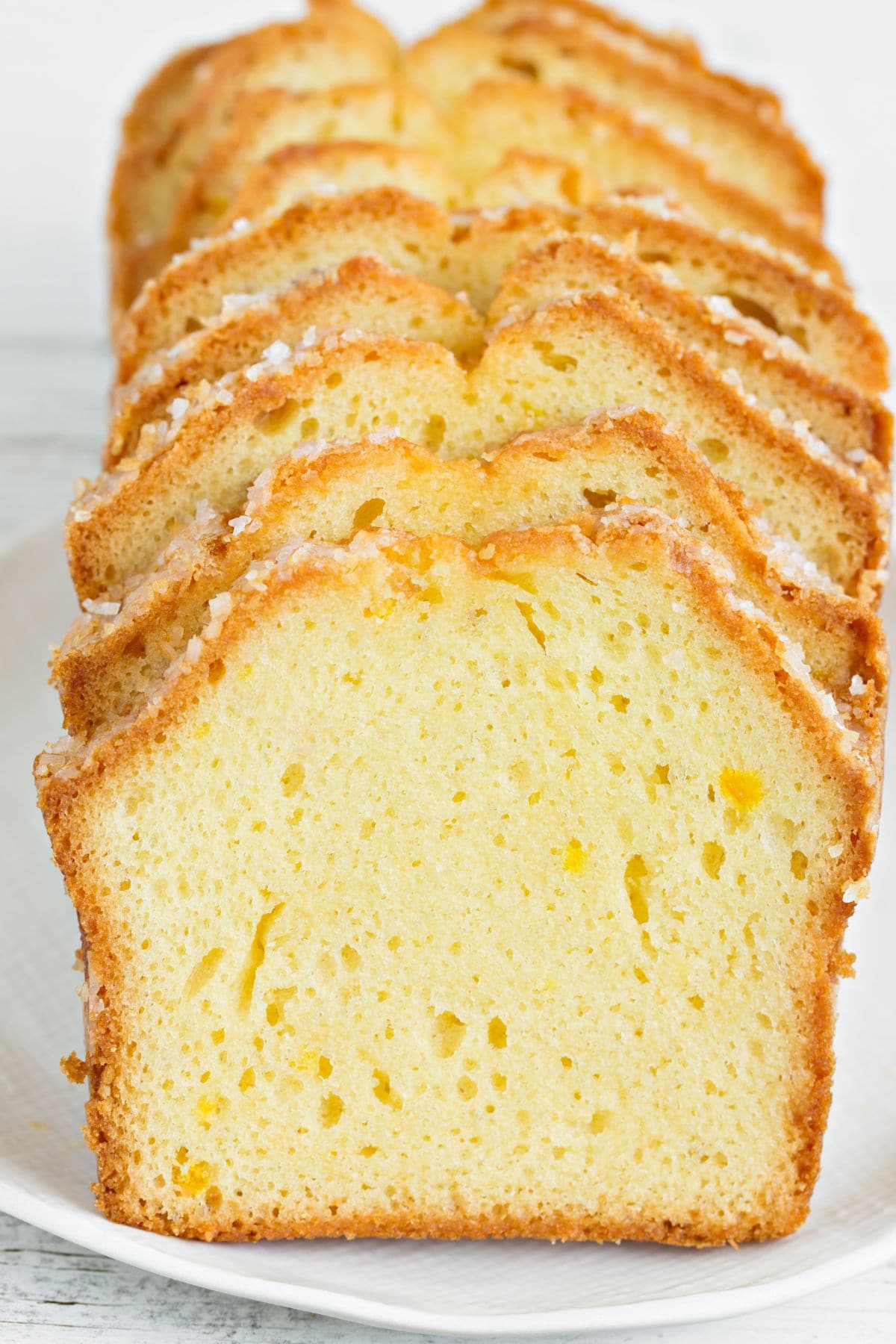 A sliced pound cake on a white plate.