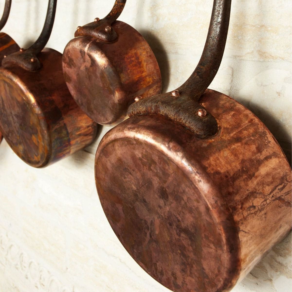 Copper saucepans hanging on the wall.
