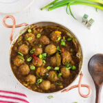 Finished Teriyaki Pineapple Meatballs in a pan with a wooden spoon.