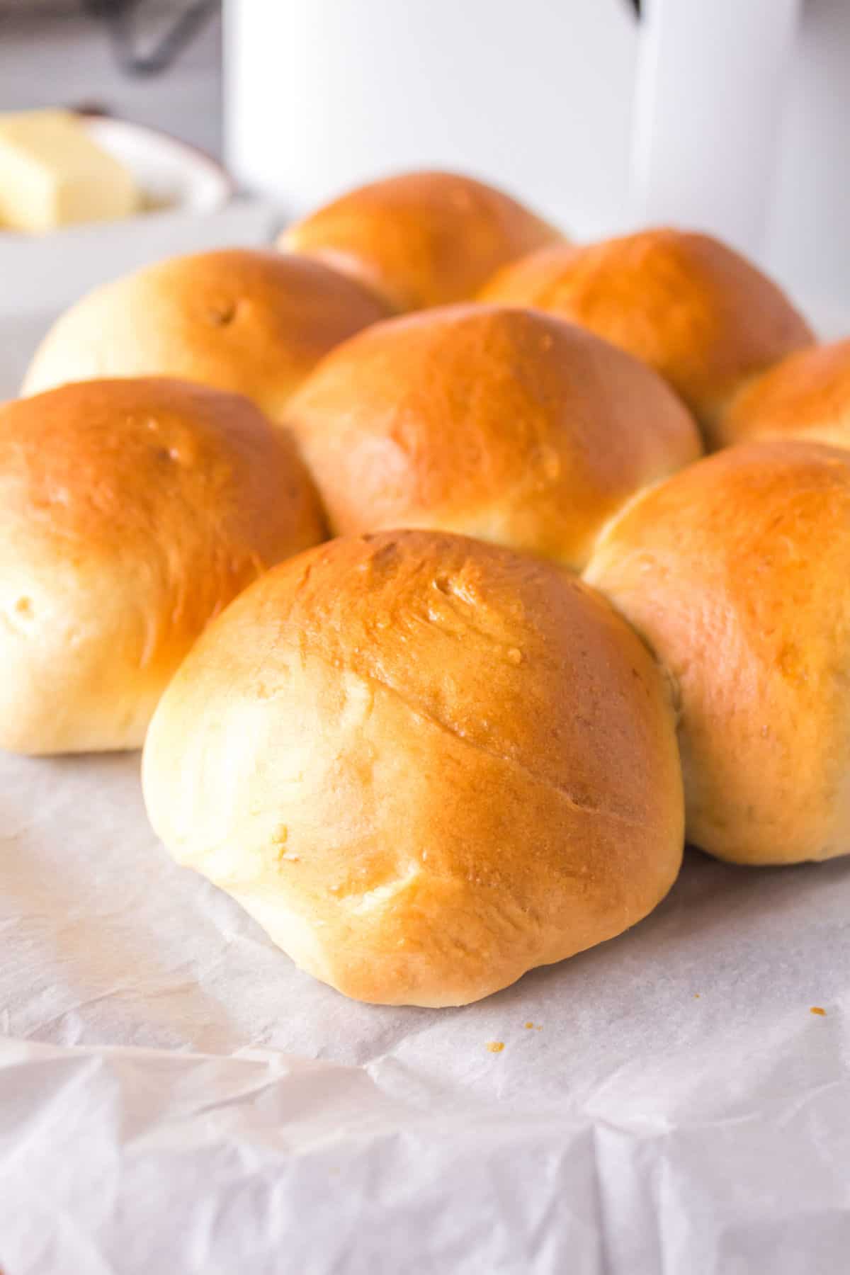 Golden brown dinner rolls on a table.
