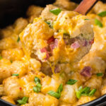 Breakfast tater tot casserole being spooned out of the slow cooker.