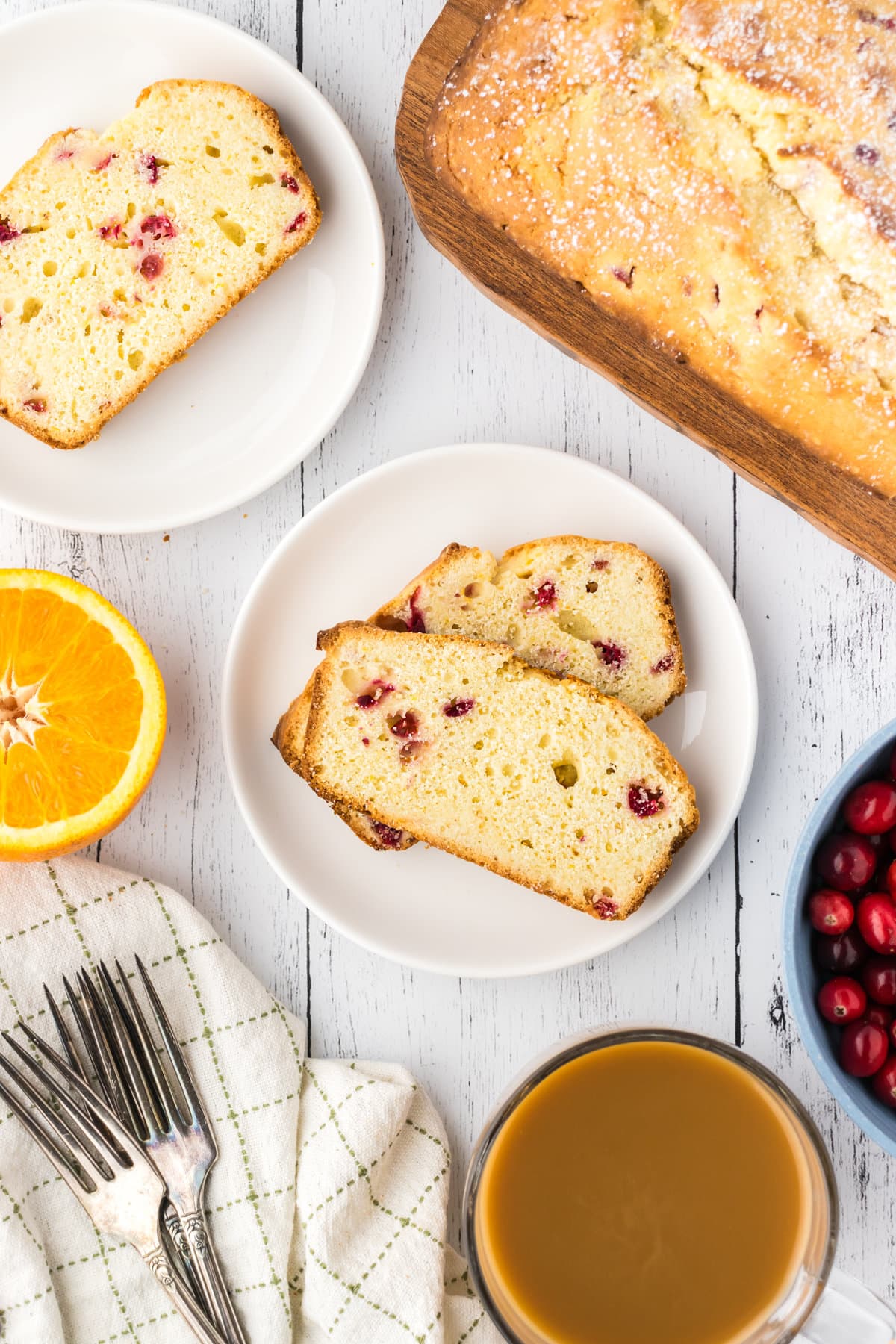 An overhead view of two slices of cranberry pound cake on a white plate. 