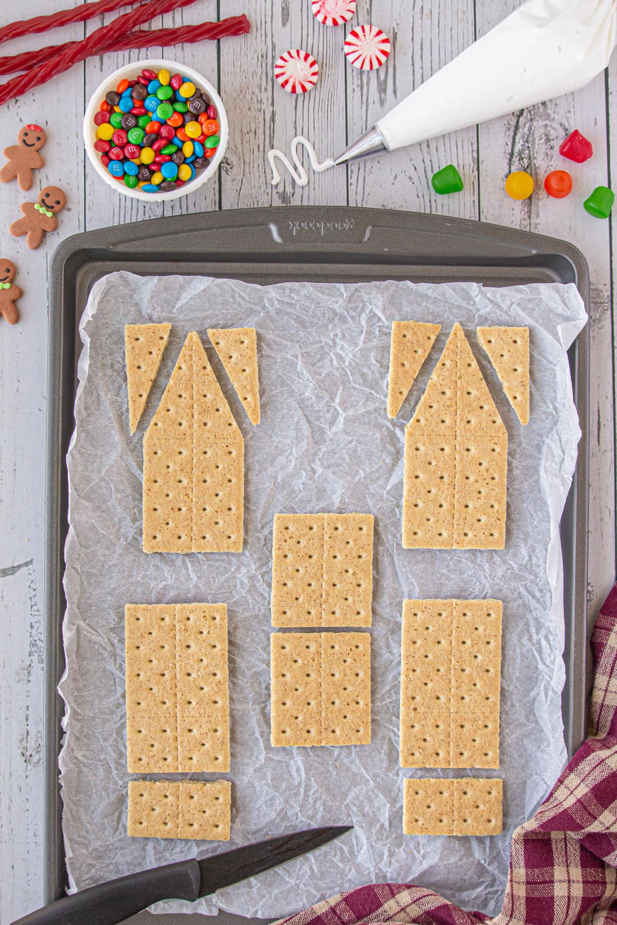 5 graham crackers cut in the shapes needed to build the gingerbread house.