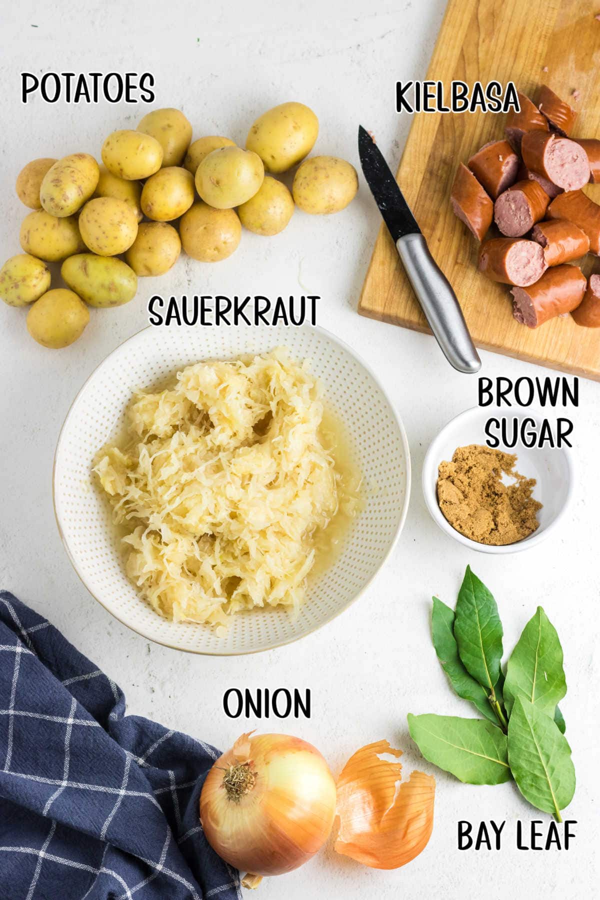 An overhead photo with text overlay showing each raw ingredient used in crockpot kielbasa, sauerkraut, and potatoes.