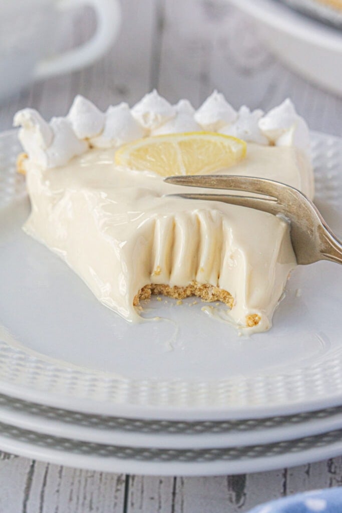 A fork digging in to a slice of lemon icebox pie.