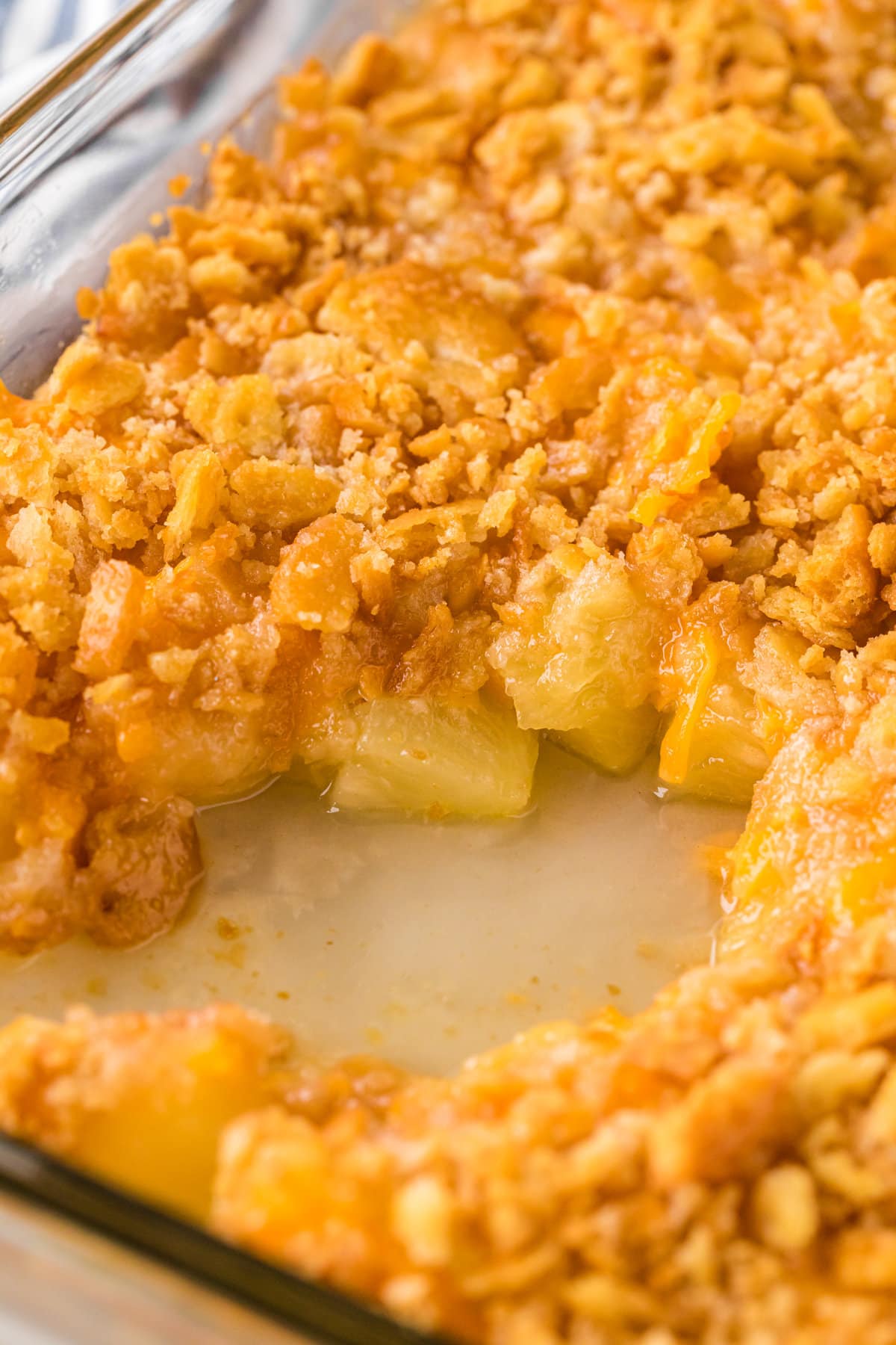 Closeup of pineapple casserole showing the juicy pineapple and the crunchy topping.