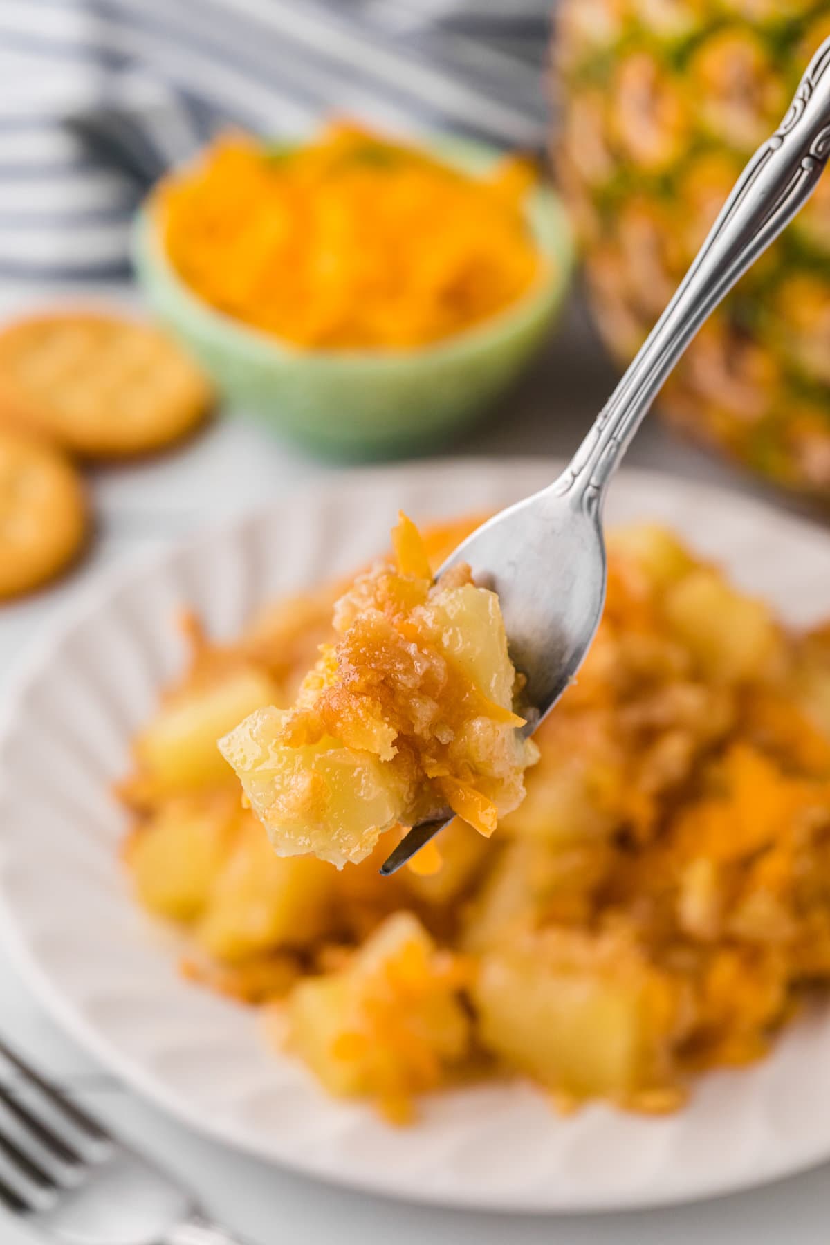 A fork with a bite of pineapple casserole on it.