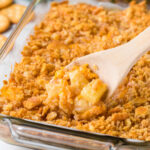 A crunchy topped casserole with a serving spoon in it.