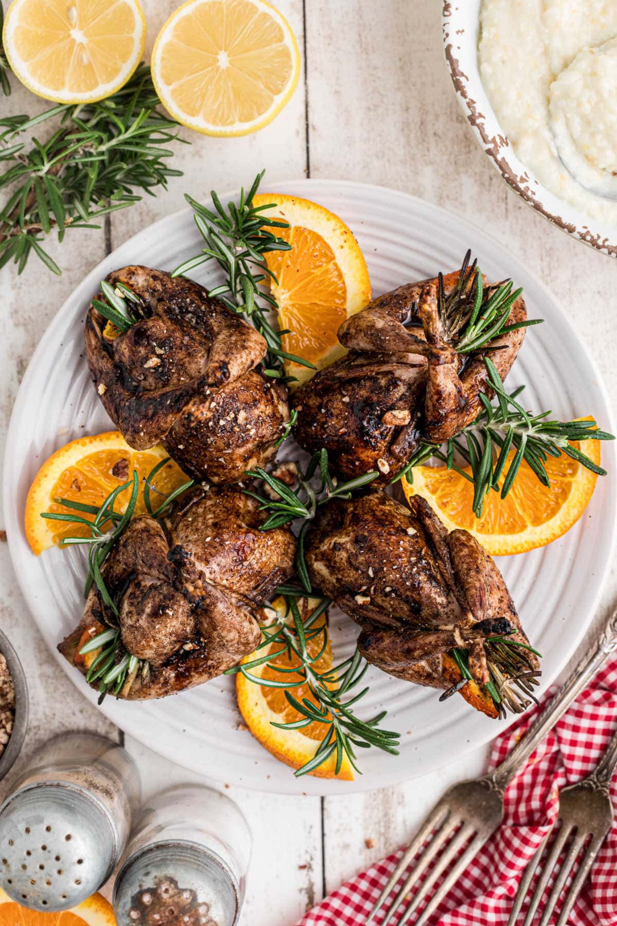 Glazed, roasted quail on a serving platter.