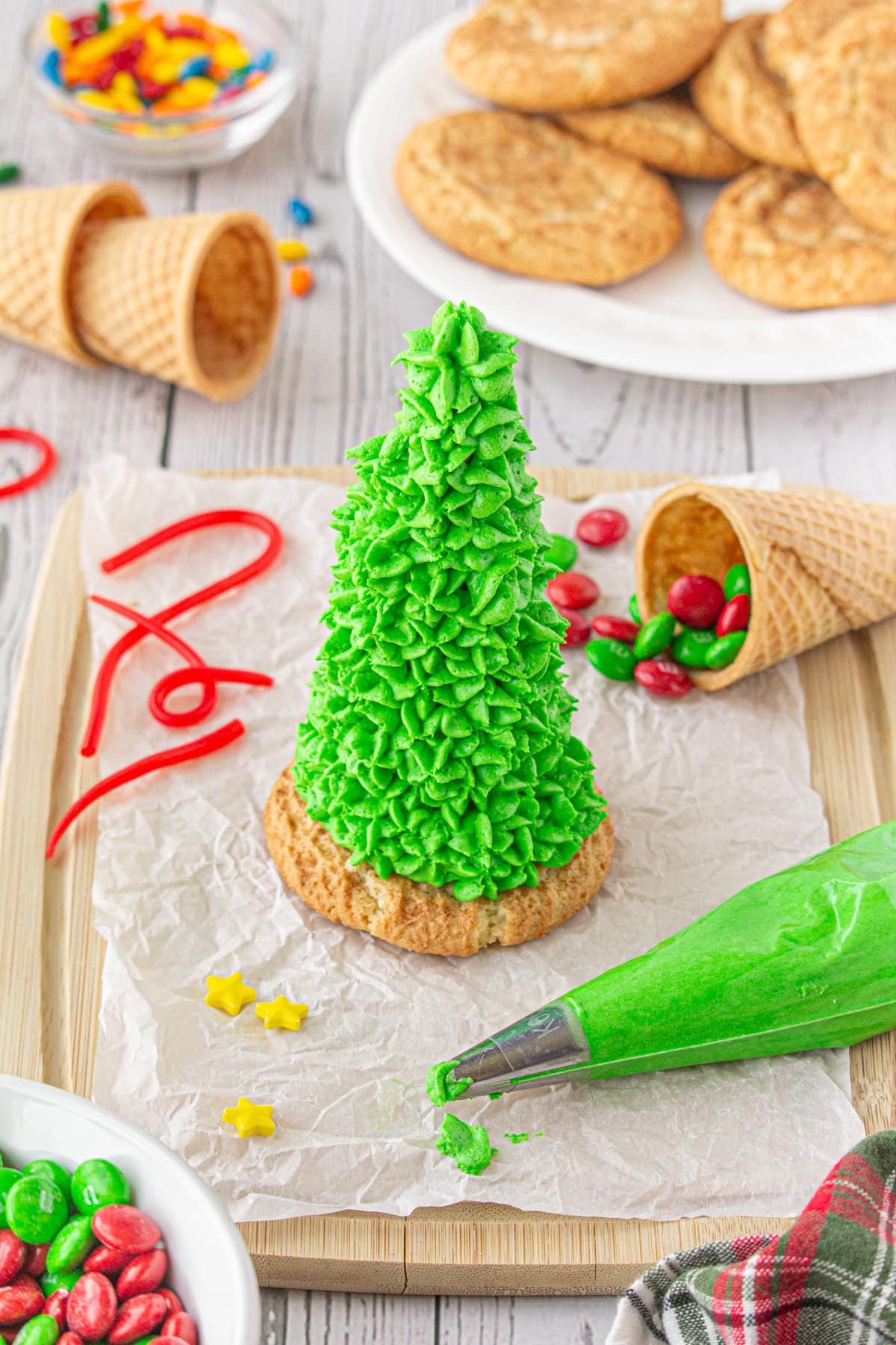 A sugar cone decorated with icing and attached to a snickerdoodle cookie so that it stands up.